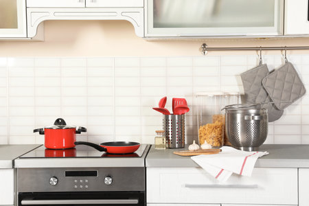 Set of clean cookware, utensils and products on table in modern kitchenの写真素材