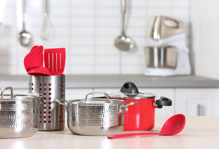 Set of clean cookware and utensils on table in kitchenの写真素材