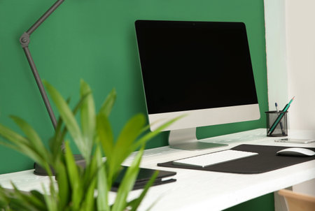 Stylish workplace with modern computer near color wall. Space for textの写真素材