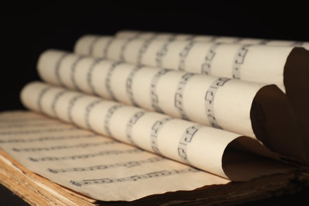 Old wrapped sheets with music notes on black background, closeupの写真素材