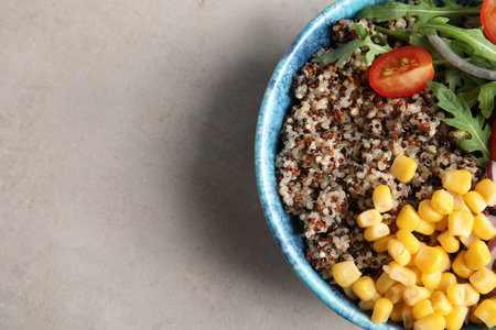Healthy quinoa salad with vegetables in bowl on color background, top view. Space for textの写真素材