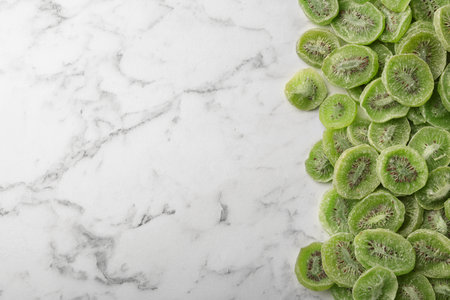 Slices of kiwi on marble background, top view with space for text. Dried fruit as healthy foodの写真素材