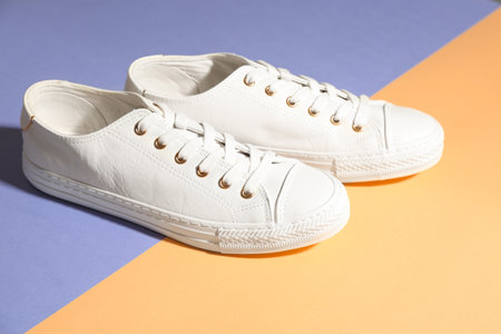 Pair of stylish sneakers on color backgroundの写真素材