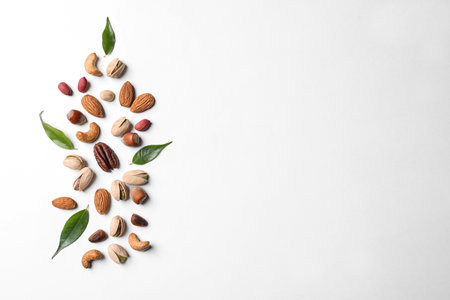 Composition with organic mixed nuts on white background, top view. Space for textの写真素材