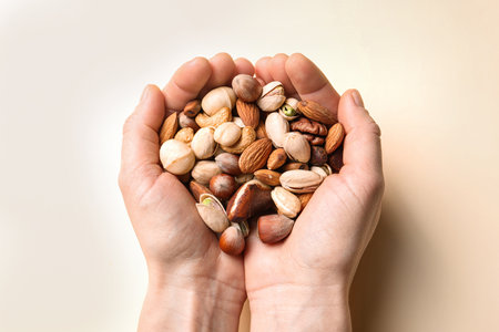 Woman holding organic mixed nuts on color background, closeupの写真素材