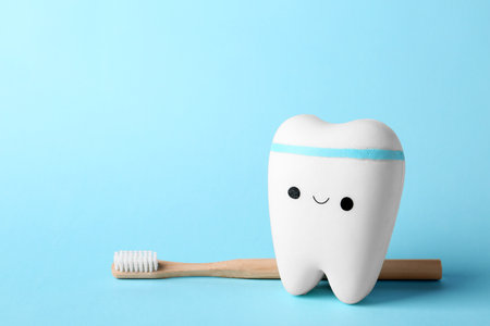 Model of tooth with happy face, brush and space for text on color backgroundの写真素材