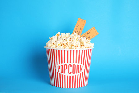 Bucket of fresh tasty popcorn and tickets on color background. cinema snackの写真素材