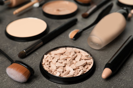 Composition with powder, skin foundation and beauty accessories on gray backgroundの写真素材