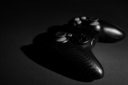 Video game controller on black background, space for textの写真素材