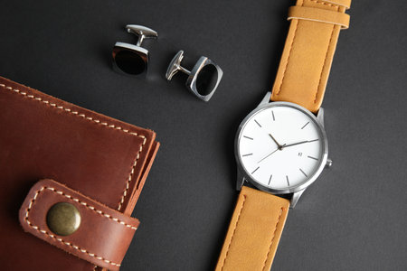 Stylish wrist watch, cuff links and wallet on black background. fashion accessoriesの写真素材