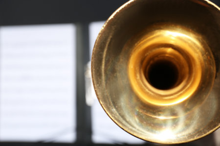 Trumpet and blurred music note sheets on background, closeup. Space for textの写真素材