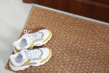 New clean mat with shoes near entrance doorの写真素材