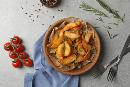 Tasty baked potatoes served with rosemary on table, flat layの写真素材