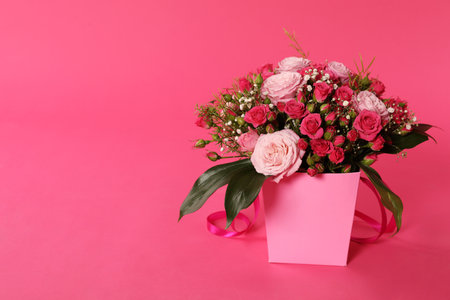 Beautiful bouquet of flowers in paper gift box on color background. Space for textの写真素材