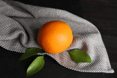 Fresh orange with leaves and napkin on tableの写真素材