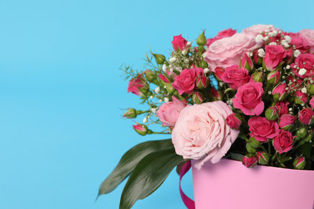 Beautiful bouquet of flowers in paper gift box on color background, closeup. Space for textの写真素材