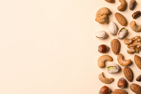 Flat lay composition with organic mixed nuts and space for text on color background