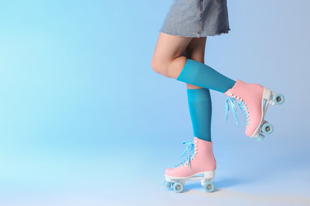 Woman with vintage roller skates on color background, closeup. Space for textの写真素材