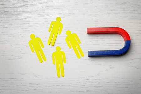 Magnet attracting people traffic on wooden background, top view. marketing conceptの写真素材