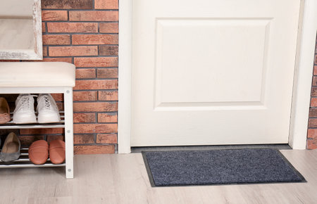Hallway interior with shoe rack and mat near doorの写真素材