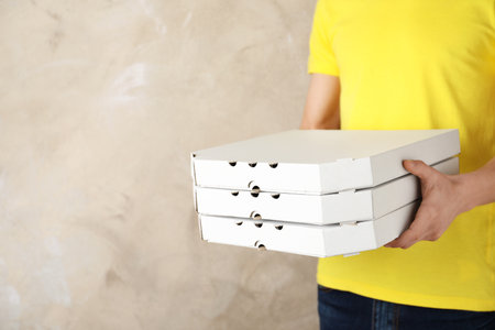 Young man with pizza boxes on color background, space for text. food delivery serviceの写真素材