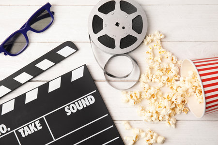 Flat lay composition with clapper, popcorn and 3D glasses on wooden background. cinema snackの写真素材