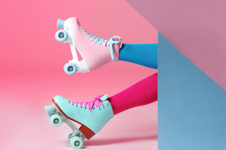 Woman with vintage roller skates on color background, closeupの写真素材