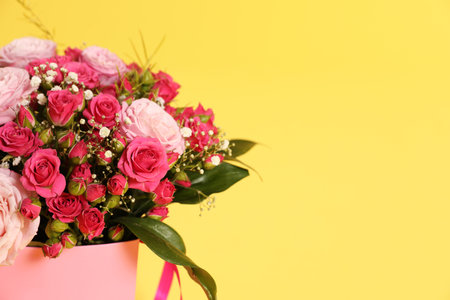 Beautiful bouquet of flowers in paper gift box on color background. Space for textの写真素材
