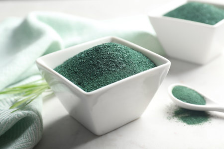 Composition with bowl of spirulina algae powder on tableの写真素材