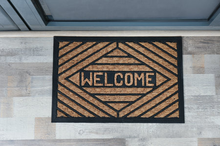 New clean mat with word WELCOME near entrance door, top viewの写真素材