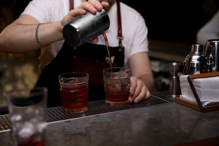 Bartender pouring tasty cocktail at counter in nightclub, closeupの写真素材