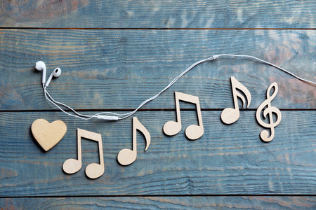 Flat lay composition with music notes and earphones on wooden backgroundの写真素材
