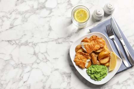 Plate with British traditional fish and potato chips on marble background, top view. Space for textの写真素材