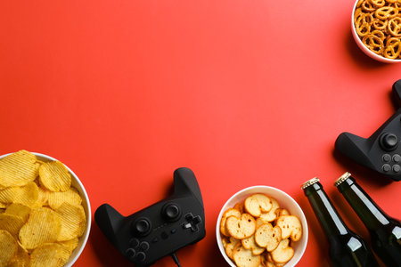 Flat lay composition with video game controllers, snacks and space for text on color backgroundの写真素材