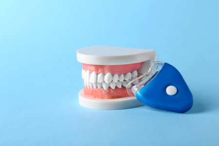 Educational model of oral cavity with teeth and whitening device on color backgroundの写真素材