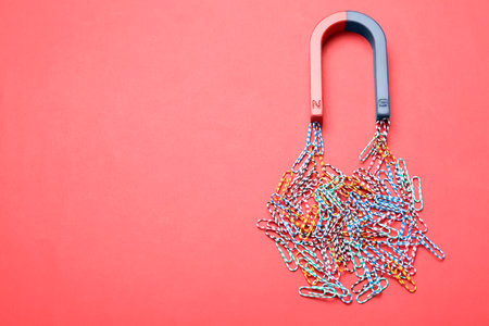 Magnet attracting paper clips on color background, space for textの写真素材