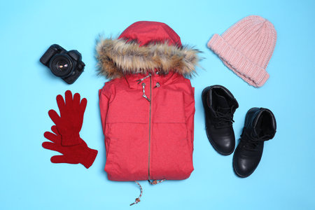 Set of warm clothes and camera on color background, flat lay. winter holidaysの写真素材