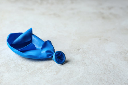 Popped balloon on gray background, space for textの写真素材