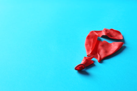 Popped balloon on color background, space for textの写真素材