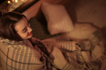 Young pretty woman with plaid resting at home. Winter seasonの写真素材