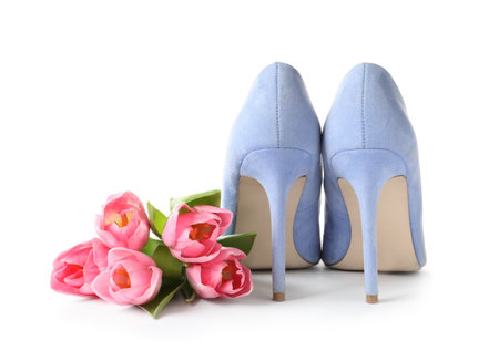 Stylish lady's shoes and beautiful spring tulips on white background. International Women's Dayの写真素材