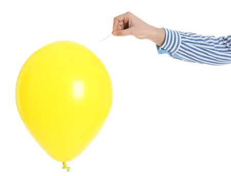 Woman piercing yellow balloon on white background, closeupの写真素材