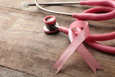 Pink ribbon and stethoscope on wooden background, space for text. breast cancer conceptの写真素材