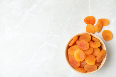 Bowl of apricots on gray background, top view with space for text. Dried fruit as healthy foodの写真素材
