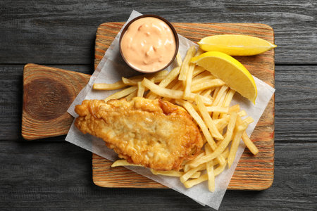 Board with British traditional fish and potato chips on wooden background, top viewの写真素材