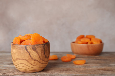 Bowl with apricots on wooden table, space for text. Dried fruit as healthy foodの写真素材