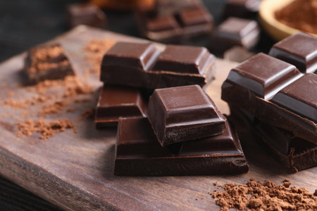 Pieces of black chocolate on wooden boardの写真素材