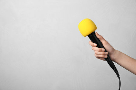 Woman holding microphone on color background, space for textの写真素材