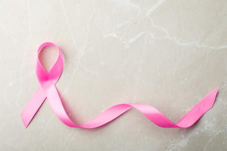 Pink ribbon on gray background, top view with space for text. breast cancer awareness conceptの写真素材