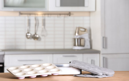 Clean baking dish, muffin pan and oven glove on table in kitchen. Space for textの写真素材